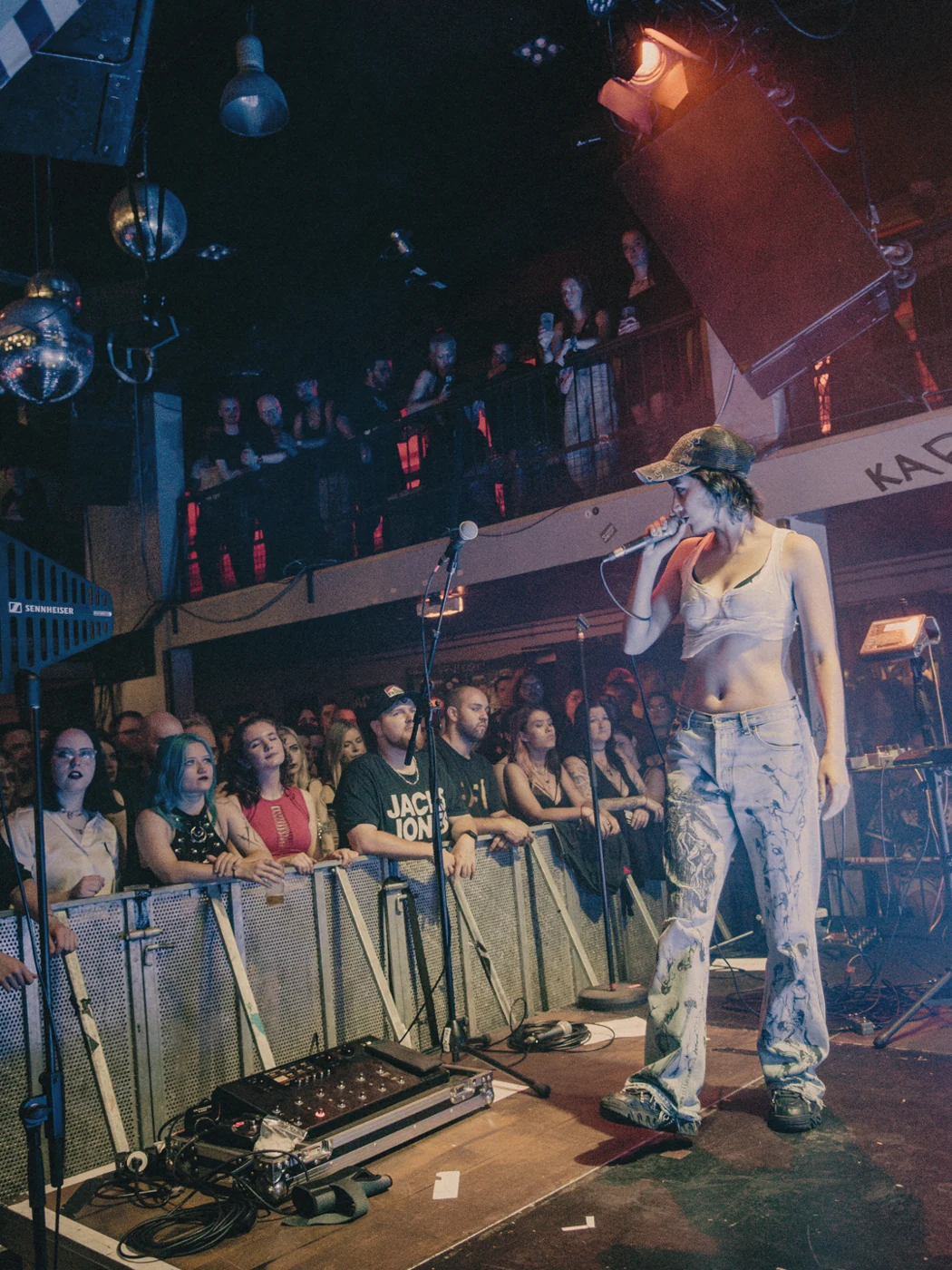 A singer performing alongside a crowd at an intimate live show