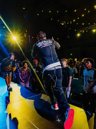 An artist performing close to the audience under yellow stage lights