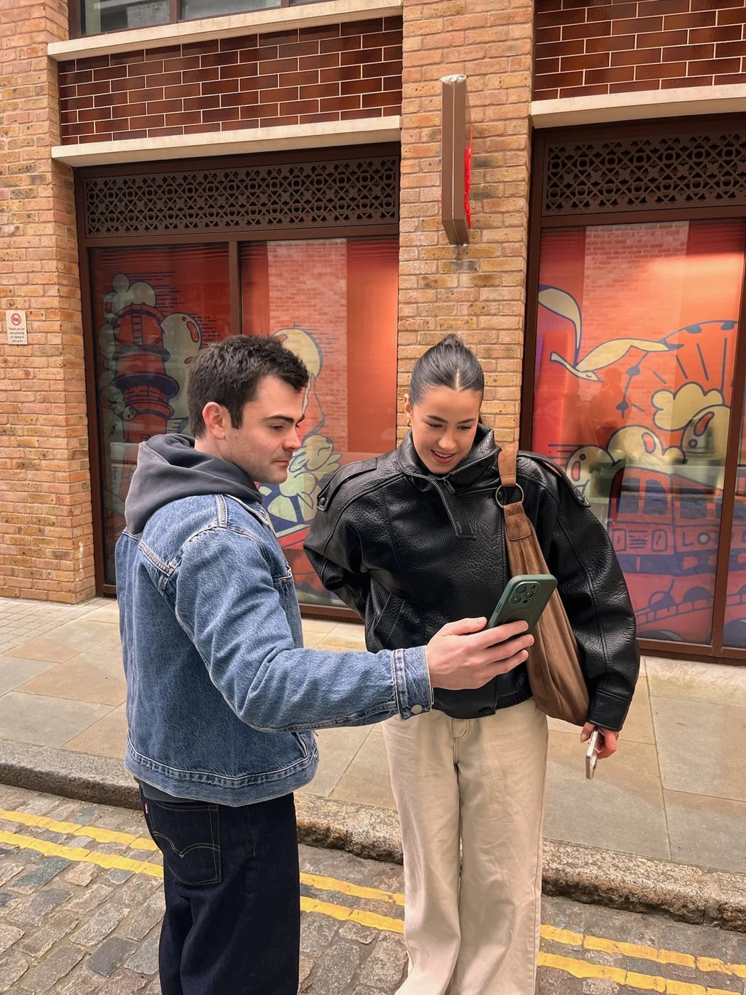 Two colleagues looking over footage on a street